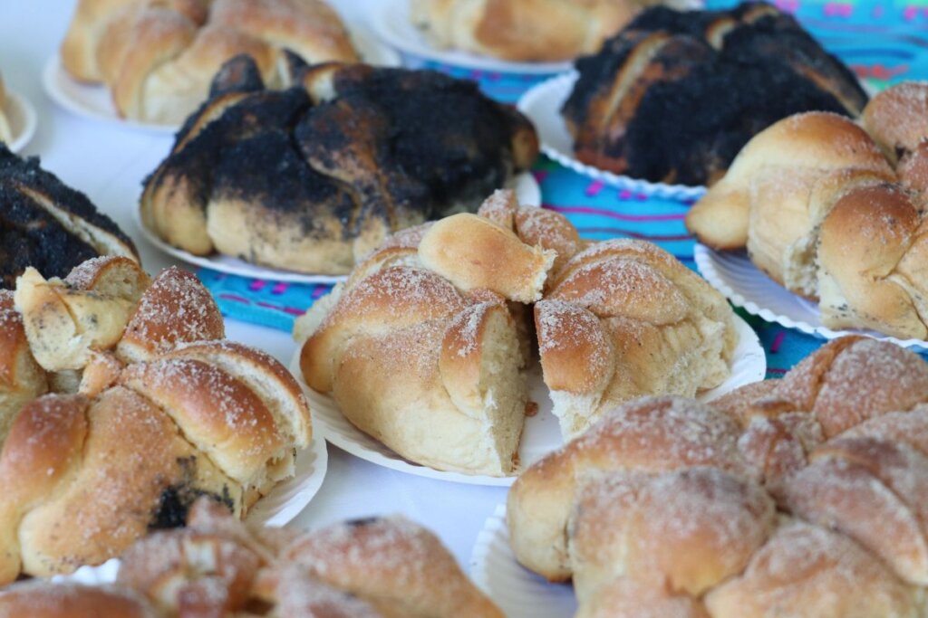 Variedades de pan de muerto elaborado de forma artesanal en Zimapán, colocado en mesas para la celebración del Día de Muertos.