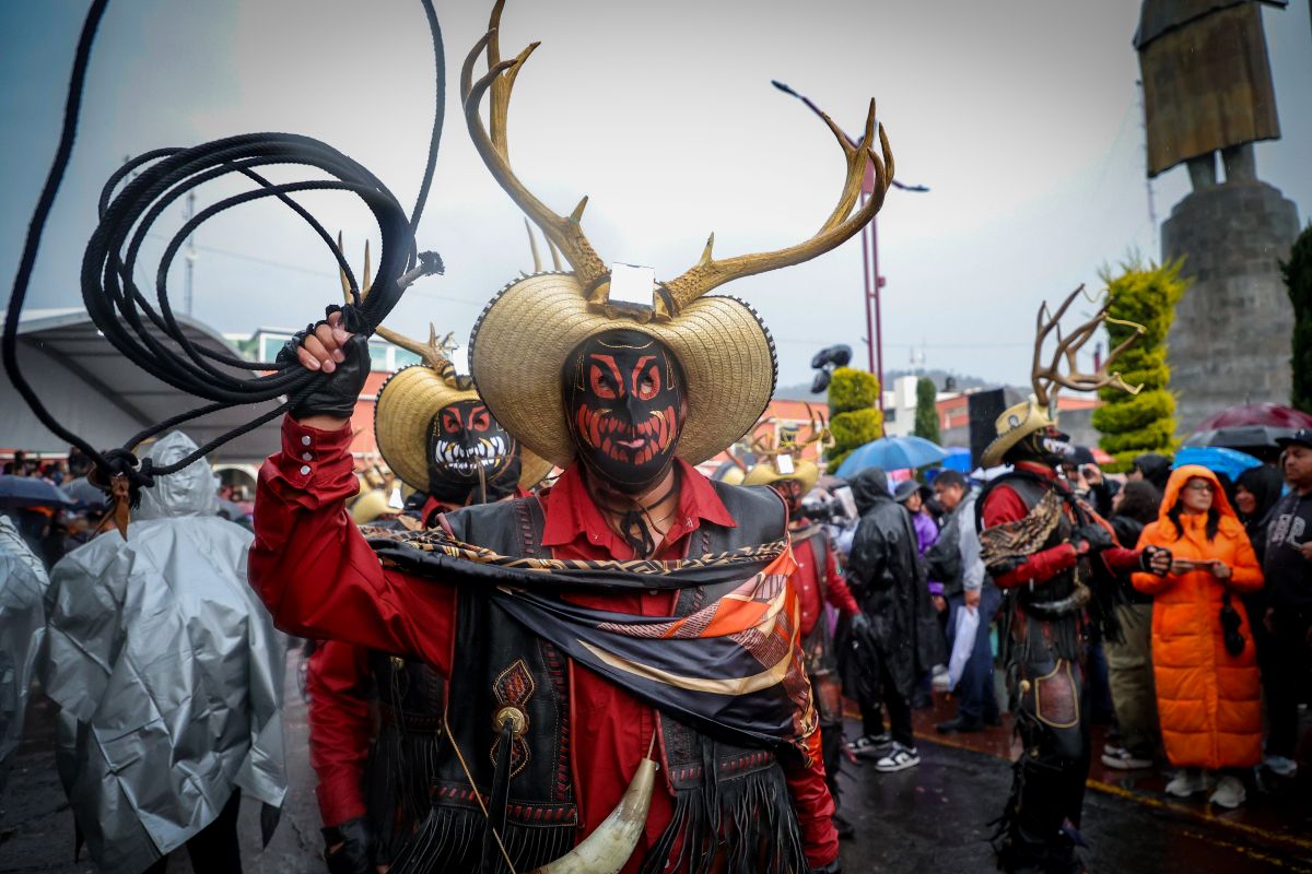Danzante del carnaval tradicional de Hidalgo con máscara y tocado durante el Desfile de Carnavales en Pachuca, como parte de la promoción cultural y turística del estado.