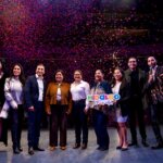 Autoridades estatales y representantes de la Feria San Francisco Pachuca Hidalgo 2026 posan en el escenario durante la presentación oficial del evento, mientras cae una lluvia de confeti al finalizar el anuncio de la cartelera del Teatro del Pueblo.