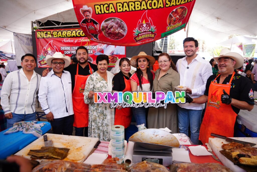 Participantes y representantes de Ixmiquilpan posan frente a un puesto de barbacoa durante el festival celebrado en Santiago de Anaya.