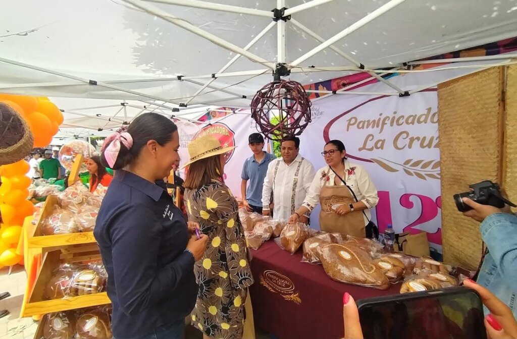 Visitantes recorren el puesto de la Panificadora La Cruz, donde se exhiben cocoles y panes artesanales.