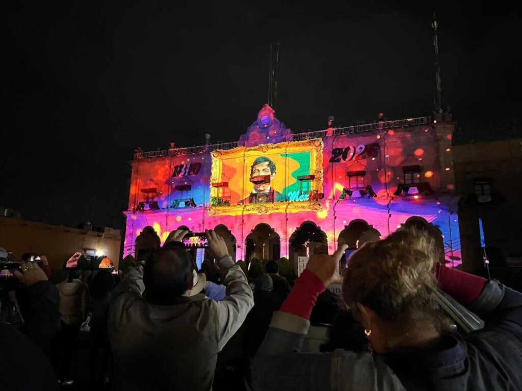 Asistentes observan y graban el videomapping proyectado sobre la Presidencia Municipal de Huichapan, Hidalgo.