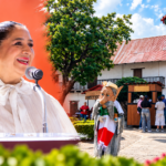 Elizabeth Quintanar Gómez, secretaria de Turismo de Hidalgo, junto a una imagen del centro de Huasca de Ocampo, que celebrará 25 años como el primer Pueblo Mágico de México.
