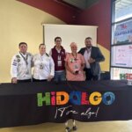Cinco participantes de la presentación de “Tulancingo Entre Sabores” posan detrás de una mesa con el logotipo turístico de Hidalgo; dos visten filipinas de chef.
